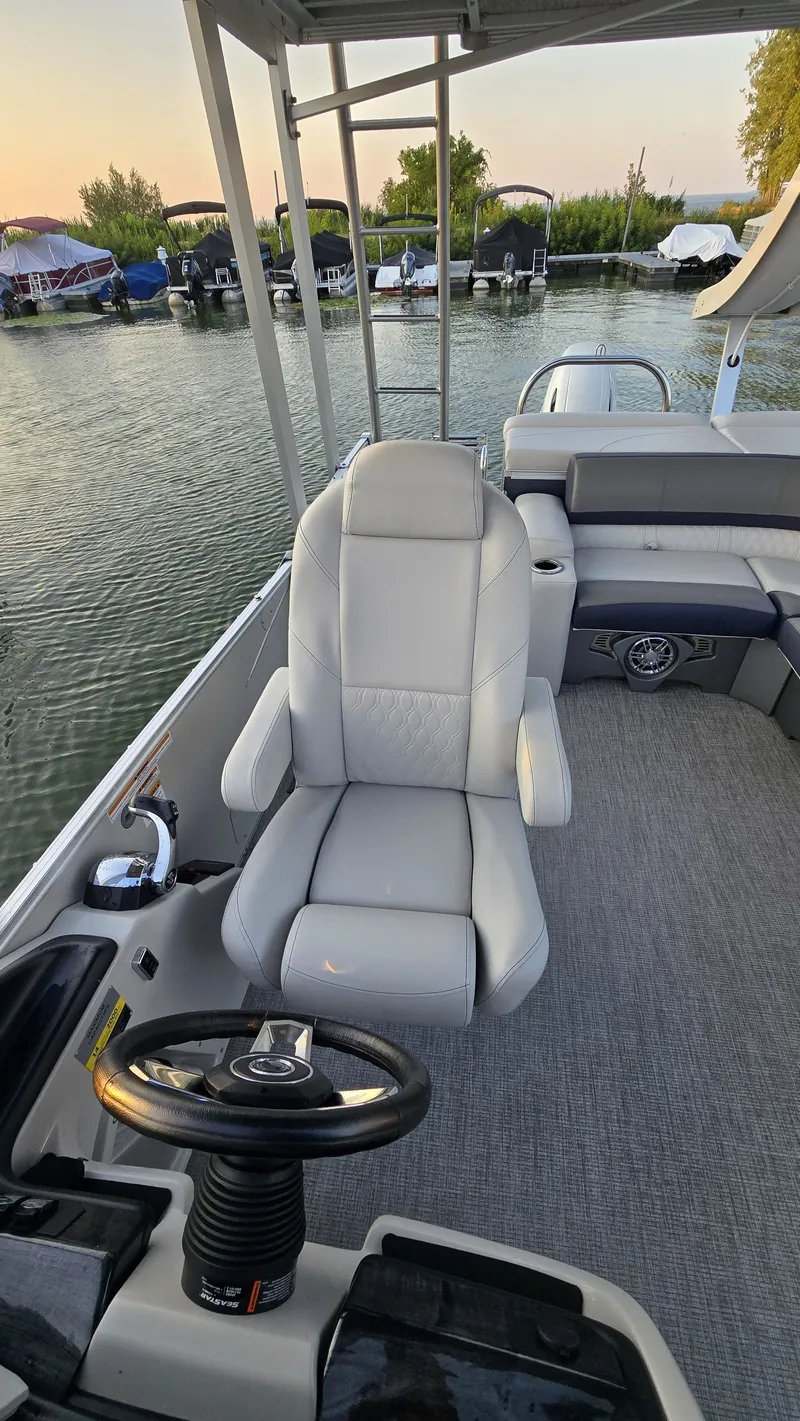 Slide: The Image of The 2023 Avalon Catalina 2585 CRFS Funship features a sleek helm with gray upholstery. - 6
