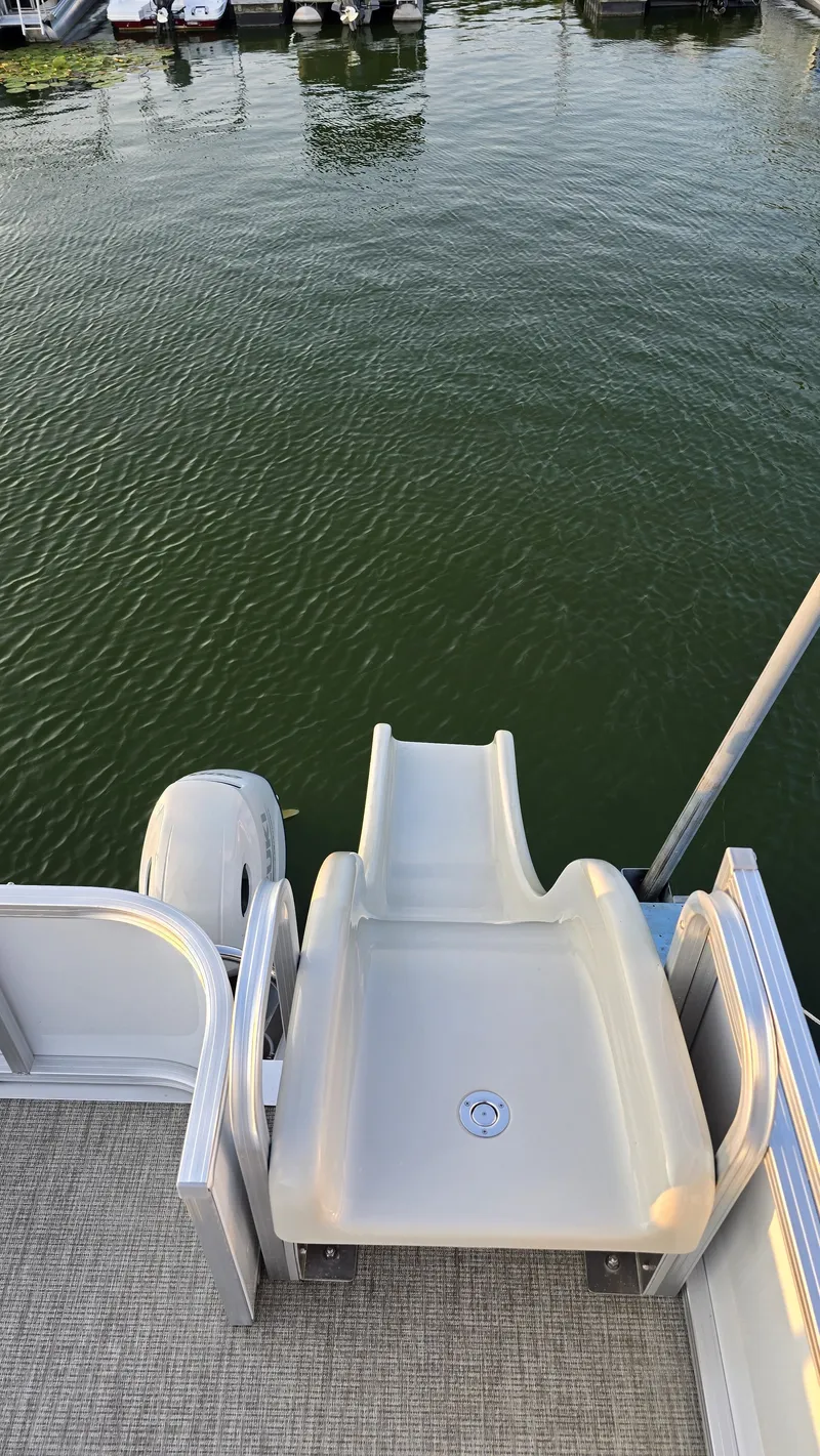 Slide: The Image of The image shows a water slide on a boat, situated on calm waters. - 23
