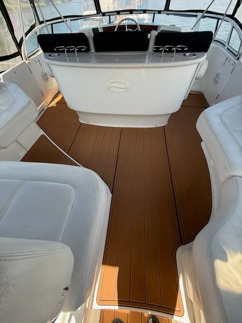 Slide: The Image of The image shows the cockpit of a 2004 Silverton 43 Motor Yacht with elegant white seating and a wooden floor. - 16