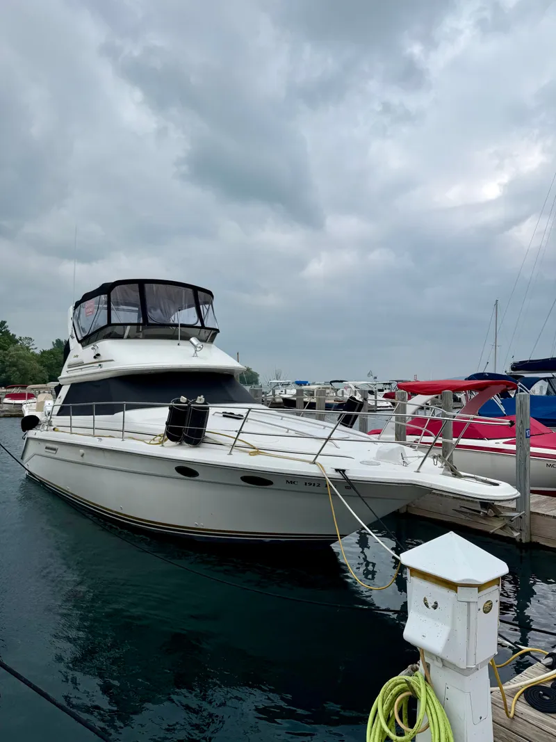 The Image of 1995 Sea Ray 370 Sedan Bridge docked, featuring a distinctive cabin and rope at the bow. - 1