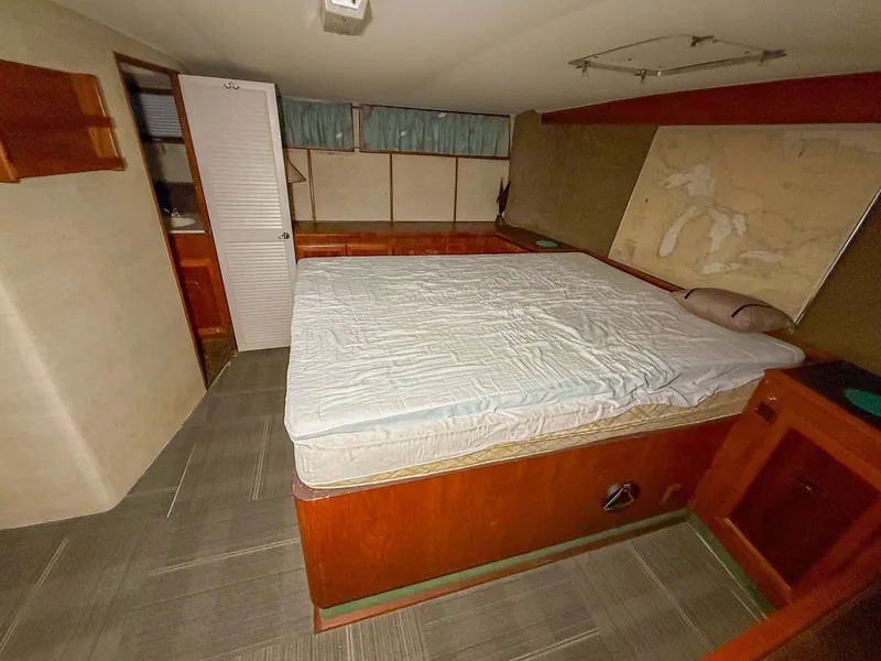 Slide: The Image of Interior of a 1977 Pacemaker FB Motor Yacht with a large bed and wooden furnishings. - 36
