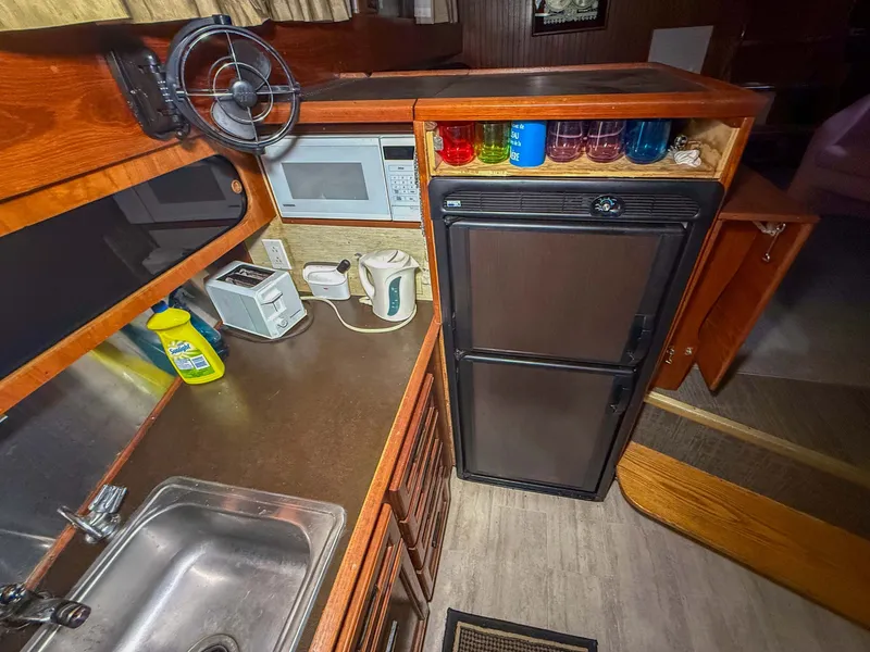 Slide: The Image of The galley of a 1977 Pacemaker FB Motor Yacht with sink, refrigerator, and microwave. - 31