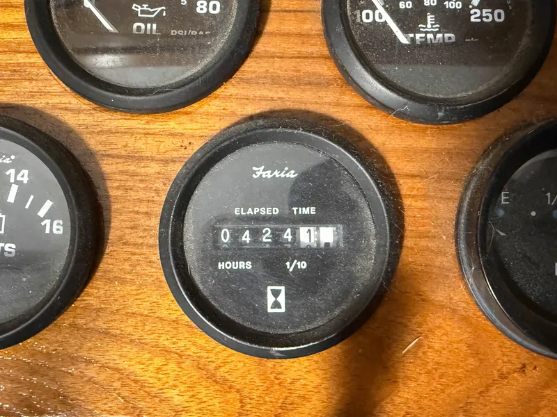 Slide: The Image of Close-up of boat instruments on wooden paneling, showing hour meter and other gauges. - 14