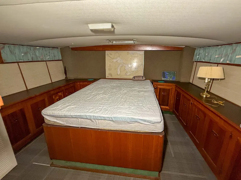 Slide: The Image of The image shows a cozy cabin with a large bed, surrounded by wooden cabinets and a lamp. - 35