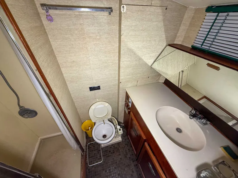 Slide: The Image of The image shows a yacht bathroom with a toilet, sink, and shower. - 38