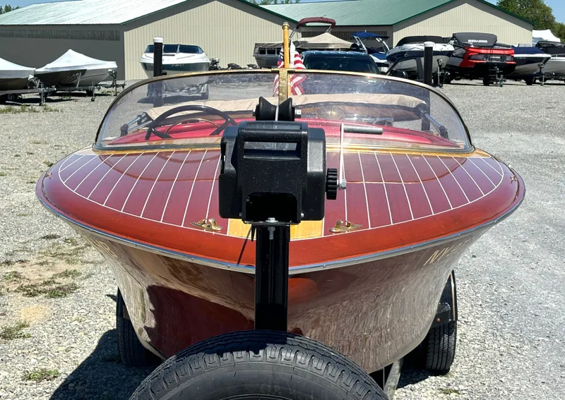 Slide: The Image of A classic 1956 Chris-Craft Capri boat with polished wood deck, on a trailer. - 8