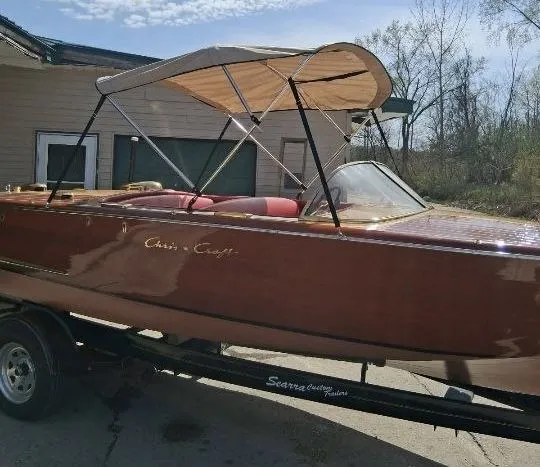 Slide: The Image of A classic 1956 Chris-Craft Capri boat with wooden finish and a beige sunshade. - 37