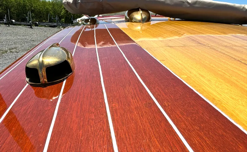 Slide: The Image of Close-up of a 1956 Chris-Craft Capri's glossy wooden deck with brass fittings. - 11