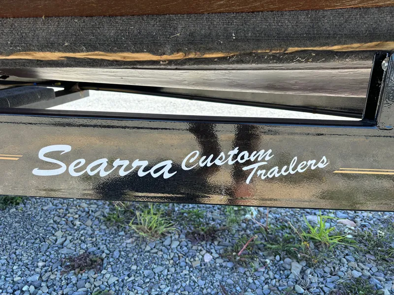 Slide: The Image of Close-up of a boat trailer with "Searra Custom Trailers" written on it, on a gravel surface. - 35