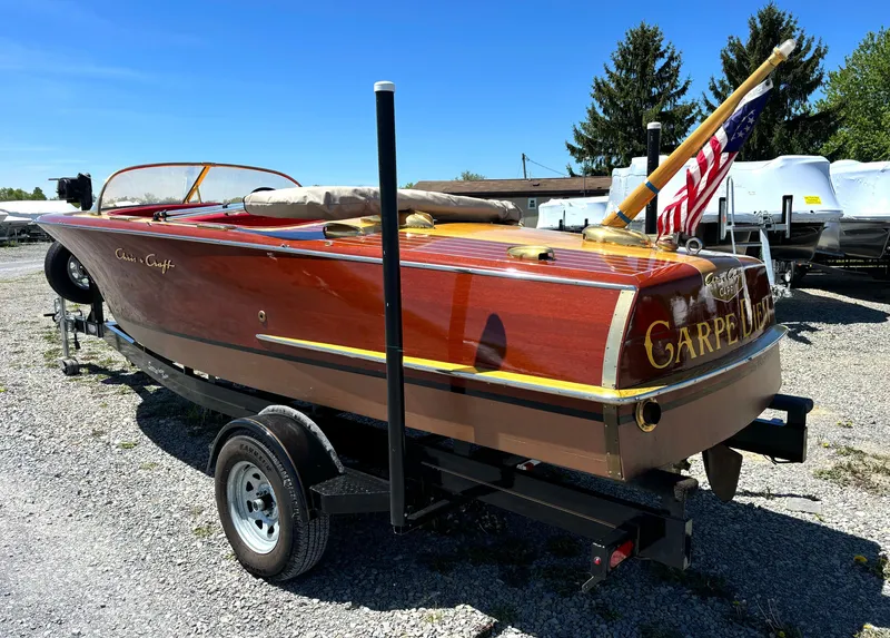 Slide: The Image of A classic 1956 Chris-Craft Capri boat with wooden finish and an American flag. - 5