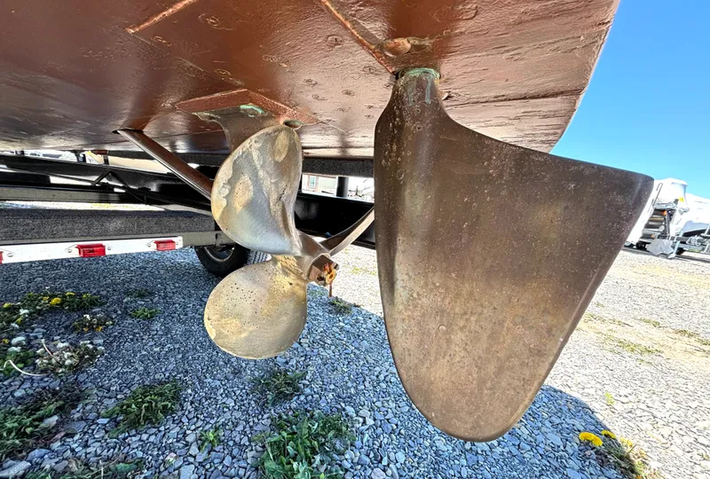 Slide: The Image of Close-up of a boat propeller and rudder on a gravel surface. - 32