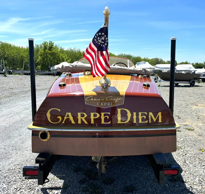 Slide: The Image of Rear view of a classic 1956 Chris-Craft Capri boat with American flag and "Carpe Diem" lettering. - 4