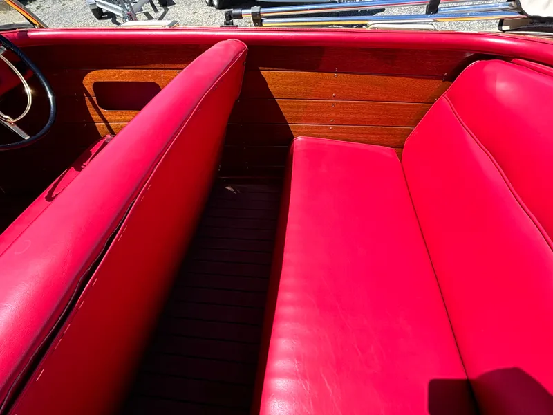Slide: The Image of Red leather seats in a classic 1956 Chris-Craft Capri, featuring wood paneling and a steering wheel. - 15