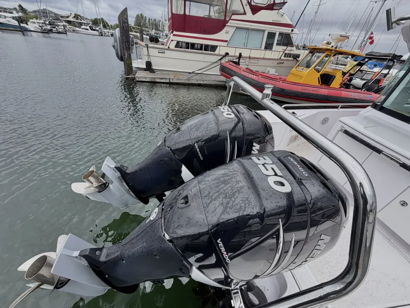 Slide: The Image of Two powerful outboard engines on a boat in a harbor, surrounded by other boats. - 40