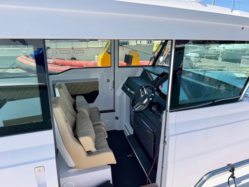 Slide: The Image of The 2020 Axopar 37 XC Cross Cabin features a modern cockpit with two beige seats. - 23