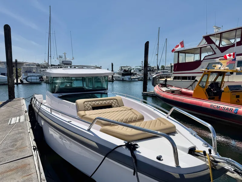 Slide: The Image of A 2020 Axopar 37 XC Cross Cabin docked in a sunny marina, surrounded by other boats. - 17