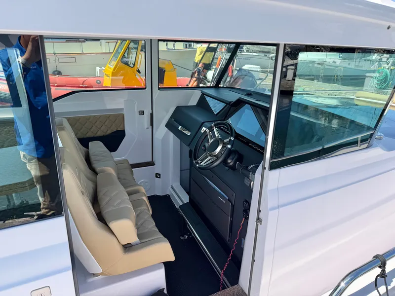 Slide: The Image of Interior view of the 2020 Axopar 37 XC Cross Cabin with beige seats and helm station. - 24