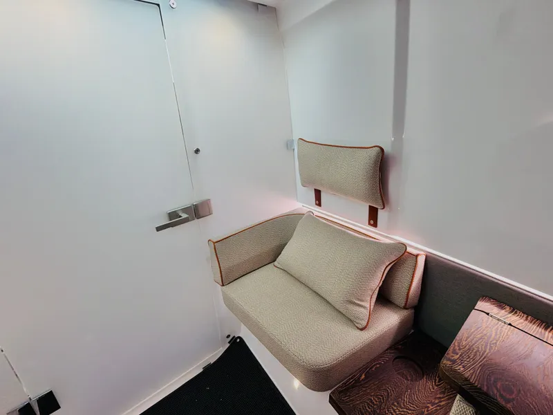 Slide: The Image of Interior of the Axopar 37 XC Cross Cabin with beige sofa and wooden table. - 38