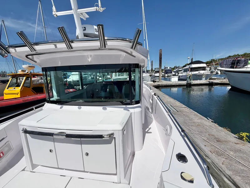 Slide: The Image of 2020 Axopar 37 XC Cross Cabin docked at a marina, surrounded by other boats. - 14
