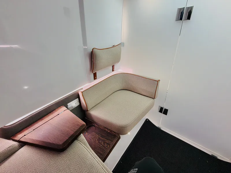 Slide: The Image of Interior of a 2020 Axopar 37 XC Cross Cabin with beige seating and wood accents. - 37