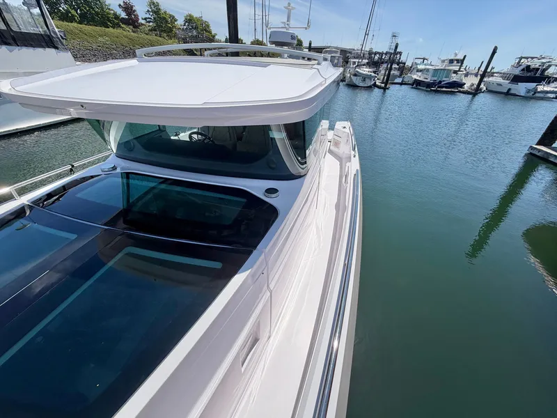 Slide: The Image of A 2020 Axopar 37 XC Cross Cabin docked in a marina. It features a sleek design and large windows. - 42