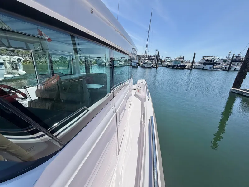 Slide: The Image of The 2020 Axopar 37 XC Cross Cabin is docked in a marina. It features a sleek design and large windows. - 43