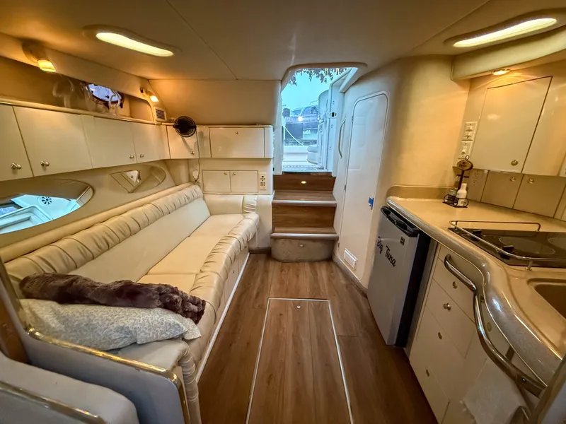 Slide: The Image of Interior of a 1997 Sea Ray 330 Express Cruiser with cozy sofa and kitchenette. - 21
