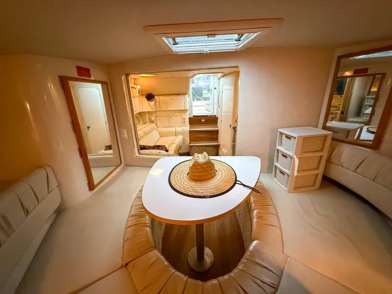 Slide: The Image of Interior of a 1997 Sea Ray 330 Express Cruiser with cozy seating area and table. - 23