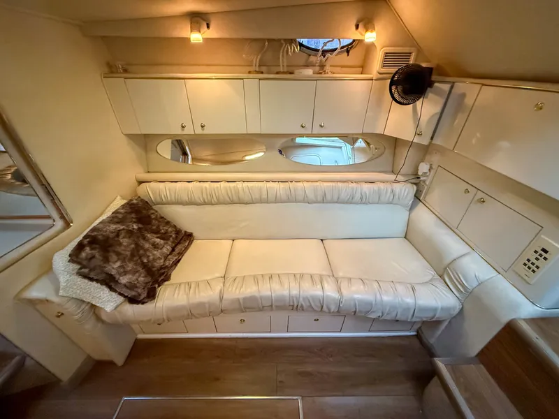 Slide: The Image of Interior of a 1997 Sea Ray 330 Express Cruiser with cream sofa and wooden flooring. - 18