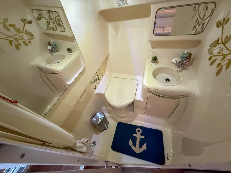 Slide: The Image of Bathroom in a 1997 Sea Ray 330 Express Cruiser with toilet, sink, and nautical decor. - 24