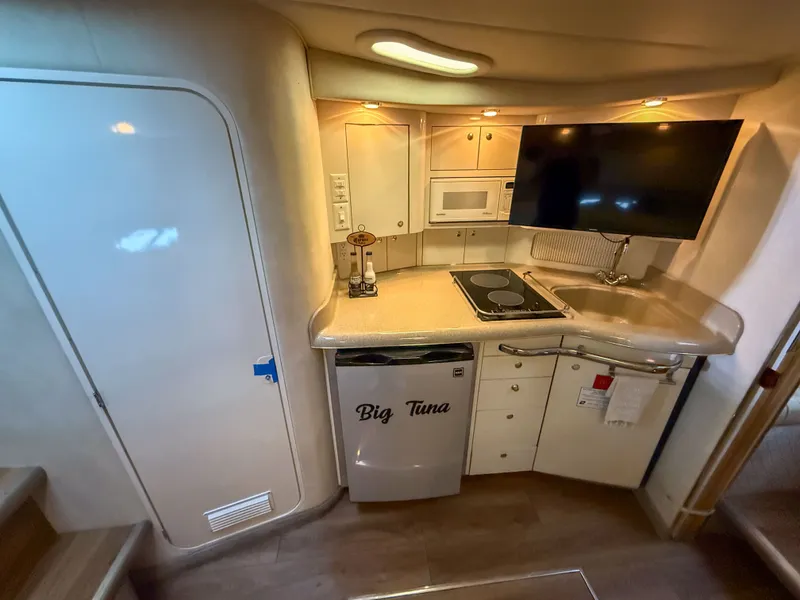 Slide: The Image of The galley of a 1997 Sea Ray 330 Express Cruiser with stove, sink, and TV. - 19