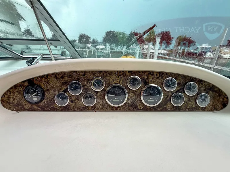 Slide: The Image of Dashboard of the 1997 Sea Ray 330 Express Cruiser with multiple gauges and wood paneling. - 14