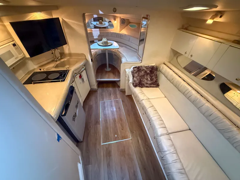 Slide: The Image of Interior of the 1997 Sea Ray 330 Express Cruiser with kitchen, sofa, and dining area. - 17