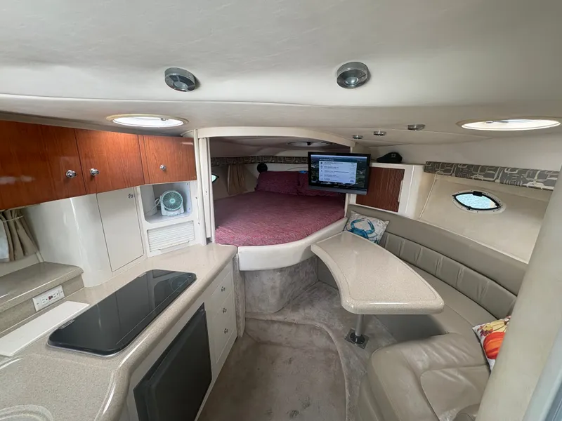 Slide: The Image of Interior of a 2000 Monterey 322 Cruiser with a kitchenette, seating area, and sleeping space. - 27