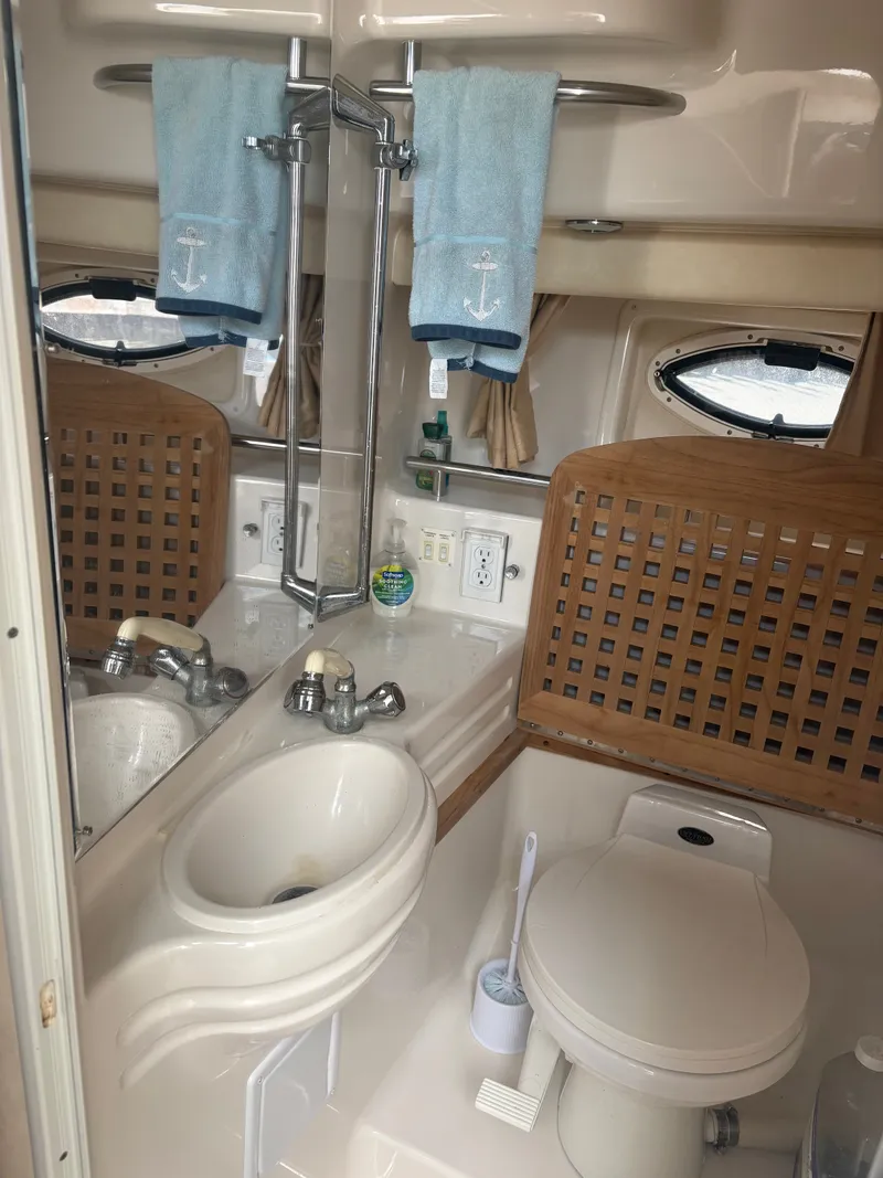 Slide: The Image of The bathroom of a 2000 Monterey 322 Cruiser with a sink, toilet, and mirror. - 44