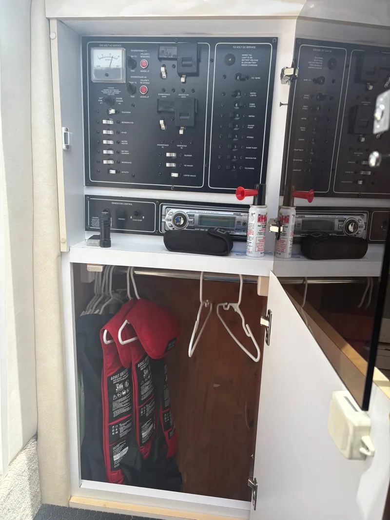 Slide: The Image of A cabinet with electronic controls and life jackets inside a boat. - 22