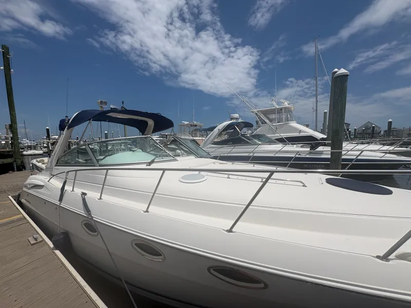 Slide: The Image of A 2000 Monterey 322 Cruiser docked on a sunny day. Several boats are visible in the background. - 5
