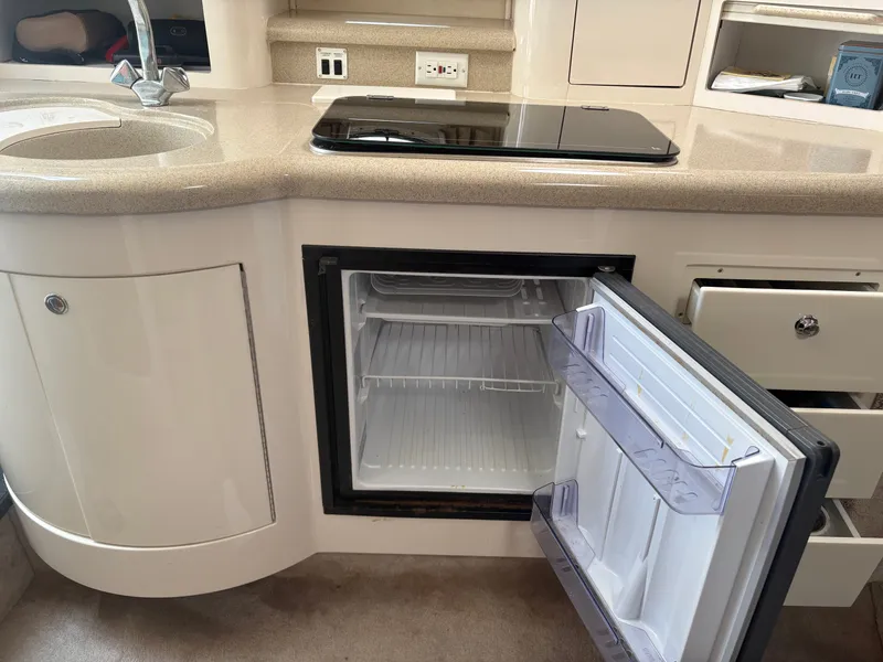 Slide: The Image of The galley of a 2000 Monterey 322 Cruiser with a sink, stove, and open refrigerator. - 37