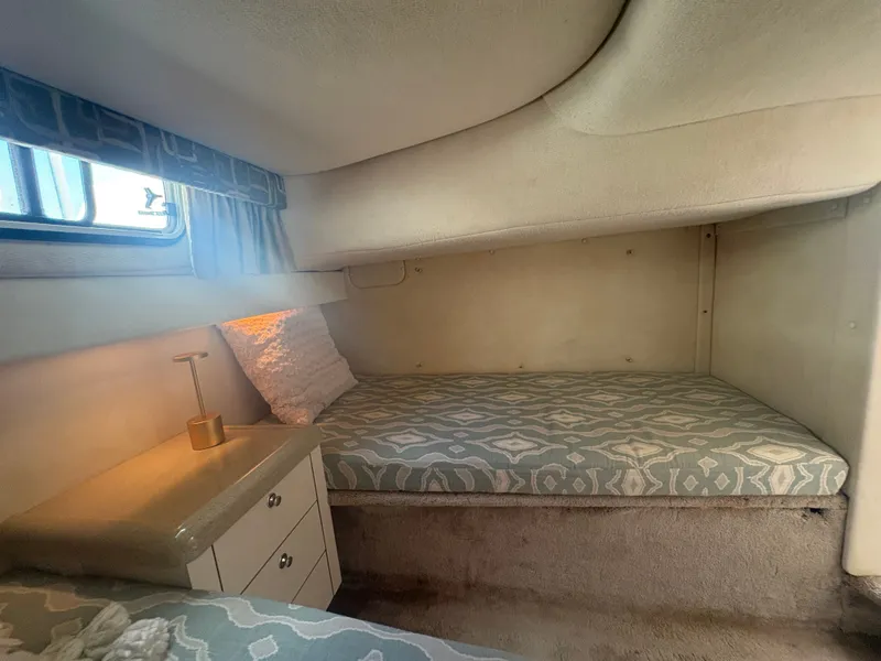 Slide: The Image of The 2000 Monterey 322 Cruiser cabin features a cozy bed with a small bedside table. - 41