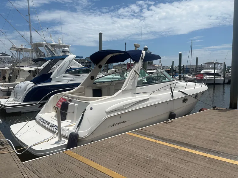 Slide: The Image of A 2000 Monterey 322 Cruiser docked on a sunny day, surrounded by other boats. - 3