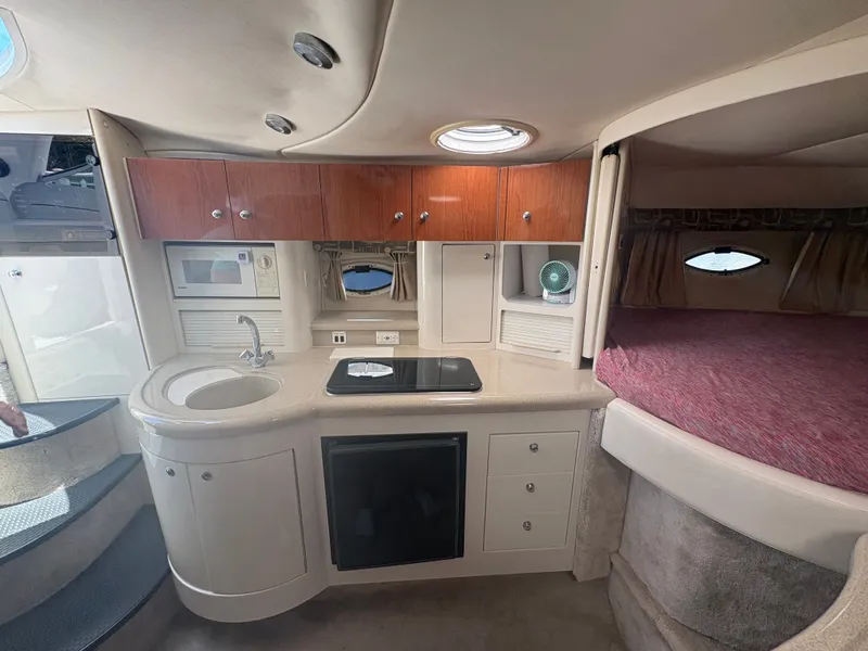 Slide: The Image of The interior cabin of a 2000 Monterey 322 Cruiser with a kitchenette and sleeping area. - 33