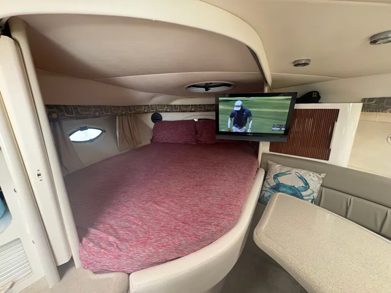 Slide: The Image of The cabin of a 2000 Monterey 322 Cruiser with a cozy bed and a television. - 28
