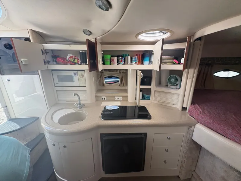 Slide: The Image of The galley of a 2000 Monterey 322 Cruiser with sink, stove, and storage. - 32