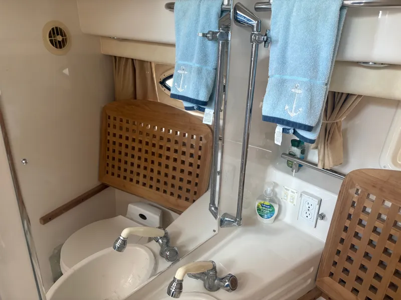 Slide: The Image of The image shows the bathroom of a 2000 Monterey 322 Cruiser with a sink and mirror. - 43