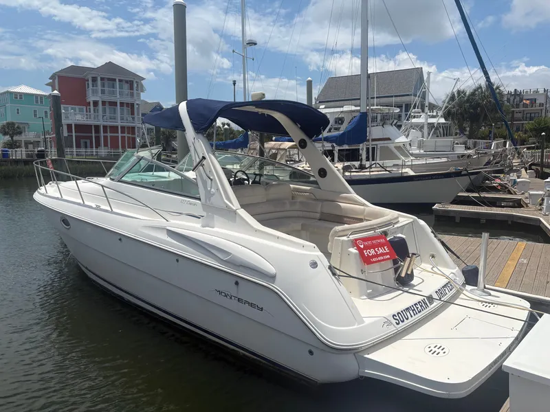 The Image of A 2000 Monterey 322 Cruiser docked, featuring a blue canopy and a 'For Sale' sign. - 1