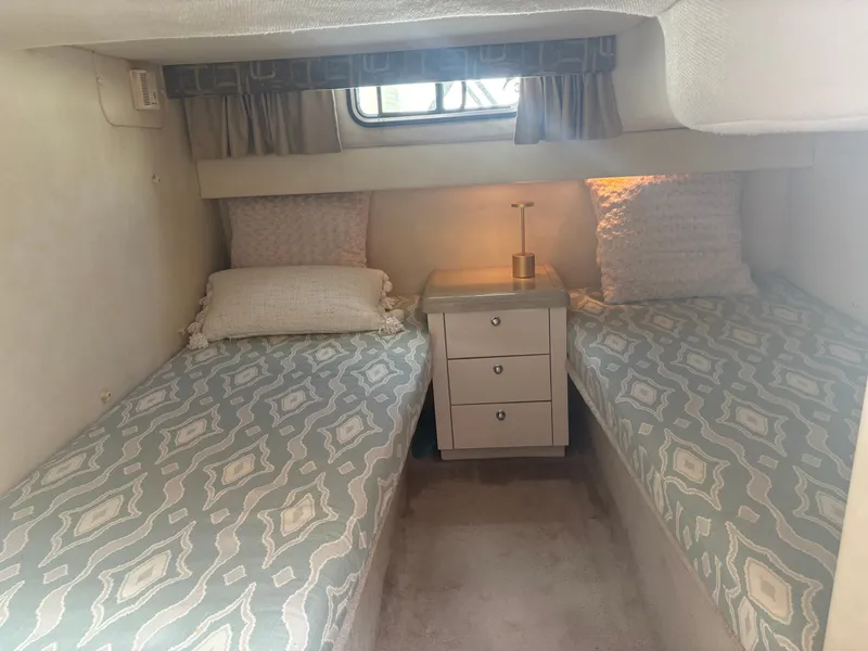 Slide: The Image of The 2000 Monterey 322 Cruiser cabin features two single beds, a nightstand, and a window. - 38