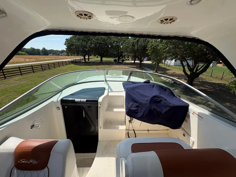 Slide: The Image of The image shows the cockpit of a 2010 Sea Ray Sundancer 310 with white seats and a blue cover. - 16