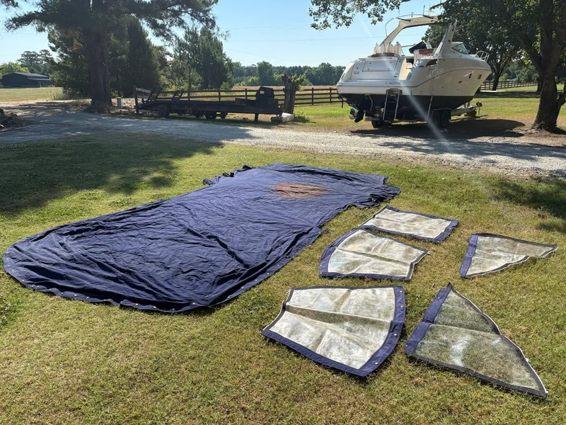 Slide: The Image of A 2010 Sea Ray Sundancer 310 is on a trailer. Covers are laid out on the grass in front. - 40