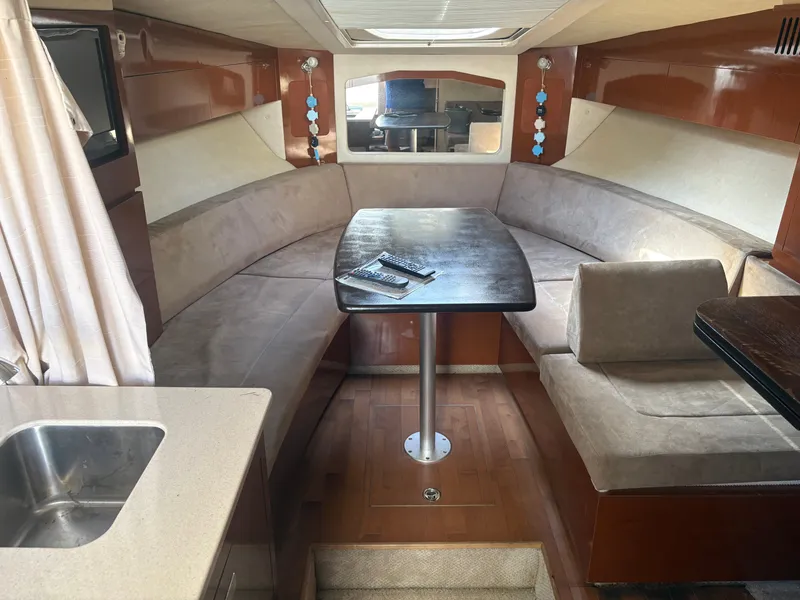 Slide: The Image of Interior of a 2010 Sea Ray Sundancer 310 with a cozy seating area and table. - 17