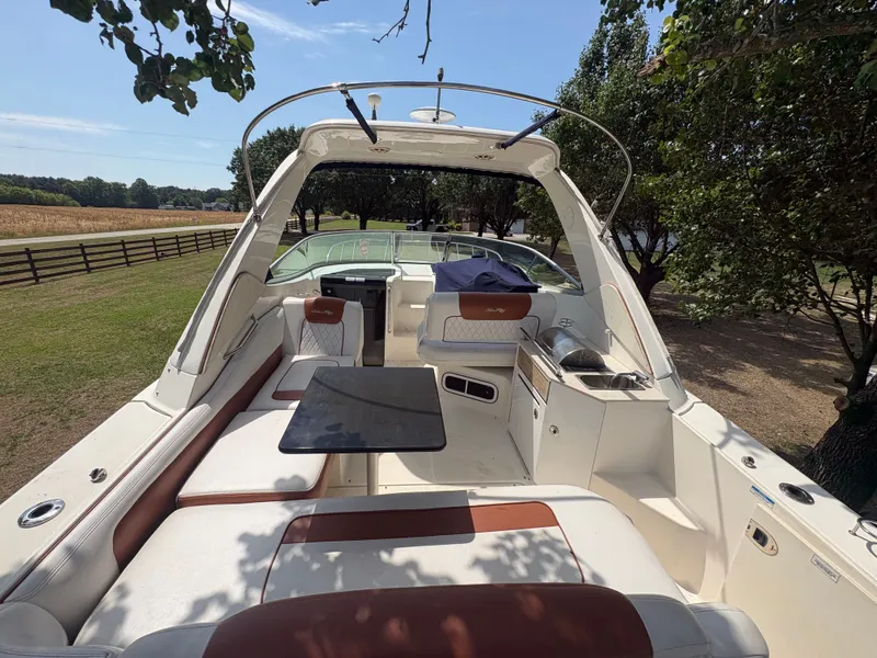 Slide: The Image of The image shows the cockpit of a 2010 Sea Ray Sundancer 310 with beige and brown seating. - 12